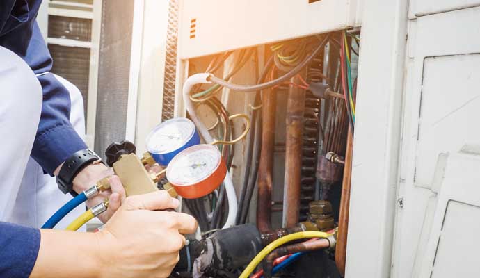 a person is checking pressure of an air conditioning unit for repairing purpose