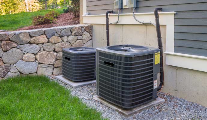 black outdoor air conditioning units placed on concrete slabs