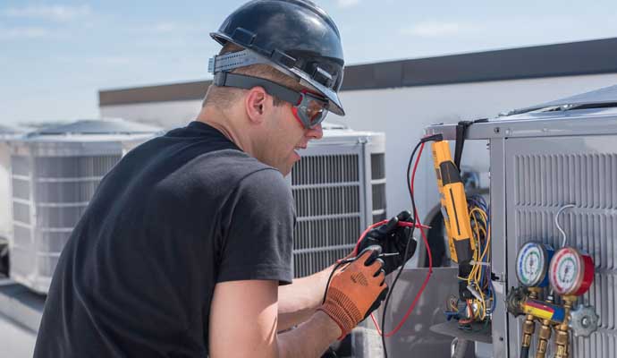 an individual working on an air conditioning unit