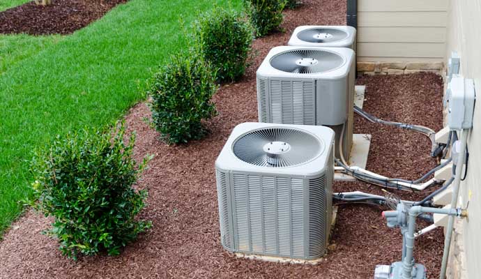 three condenser placed beside a residential building