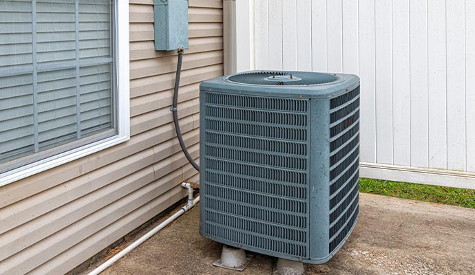 installed outdoor air conditioning unit placed on a concrete pad