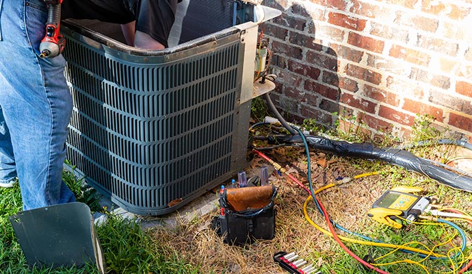 An outdoor AC unit is undergoing maintenance.