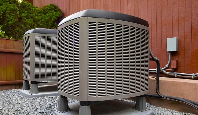 two large outdoor air conditioning units placed on a bed of gravel