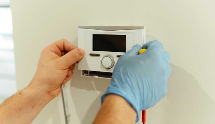 Professional installing thermostat