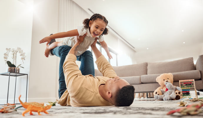 parent playing with children in a clean room