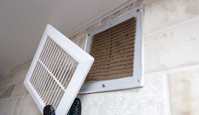 Person cleaning duct vent