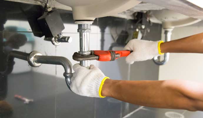 a person is working on the plumbing beneath a sink