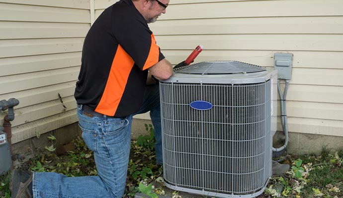 a technician working on installing an outdoor air conditioning