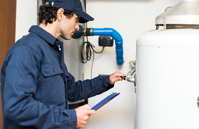 A technician performing maintenance on a water heater.