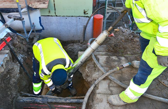 Worker relocating a water pipe for maintenance.